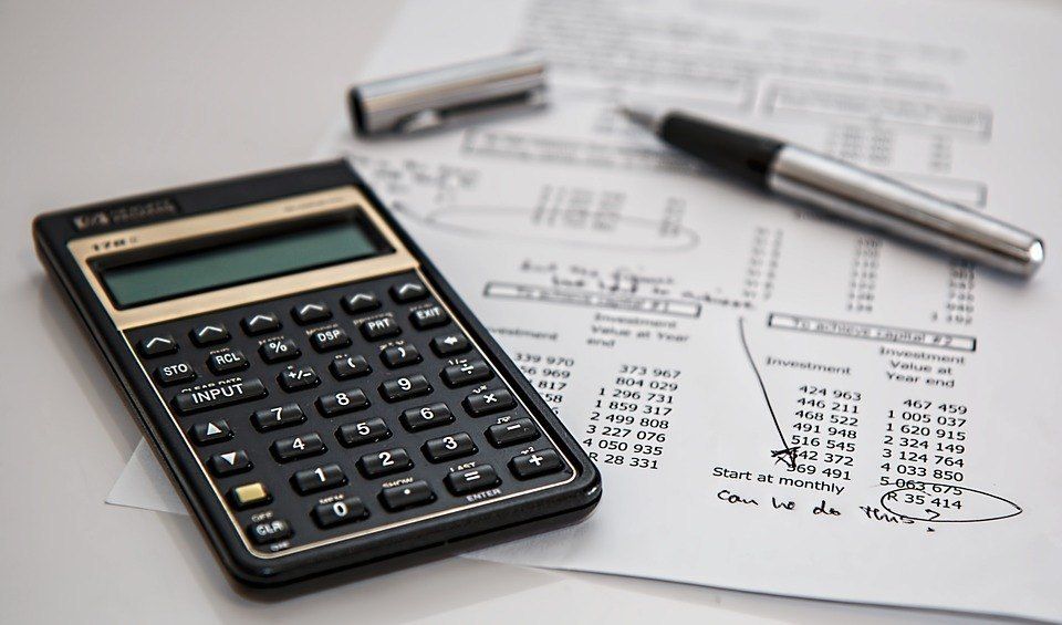 Calculadora y bolígrafo sobre un informe de inversiones